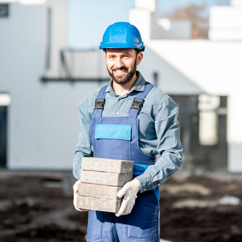 Builder laying paving tiles