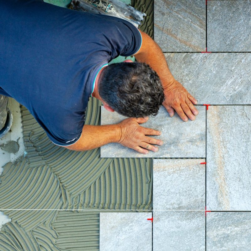 Tiler carefully lays every single tile with the help of a wire to respect the geometry.